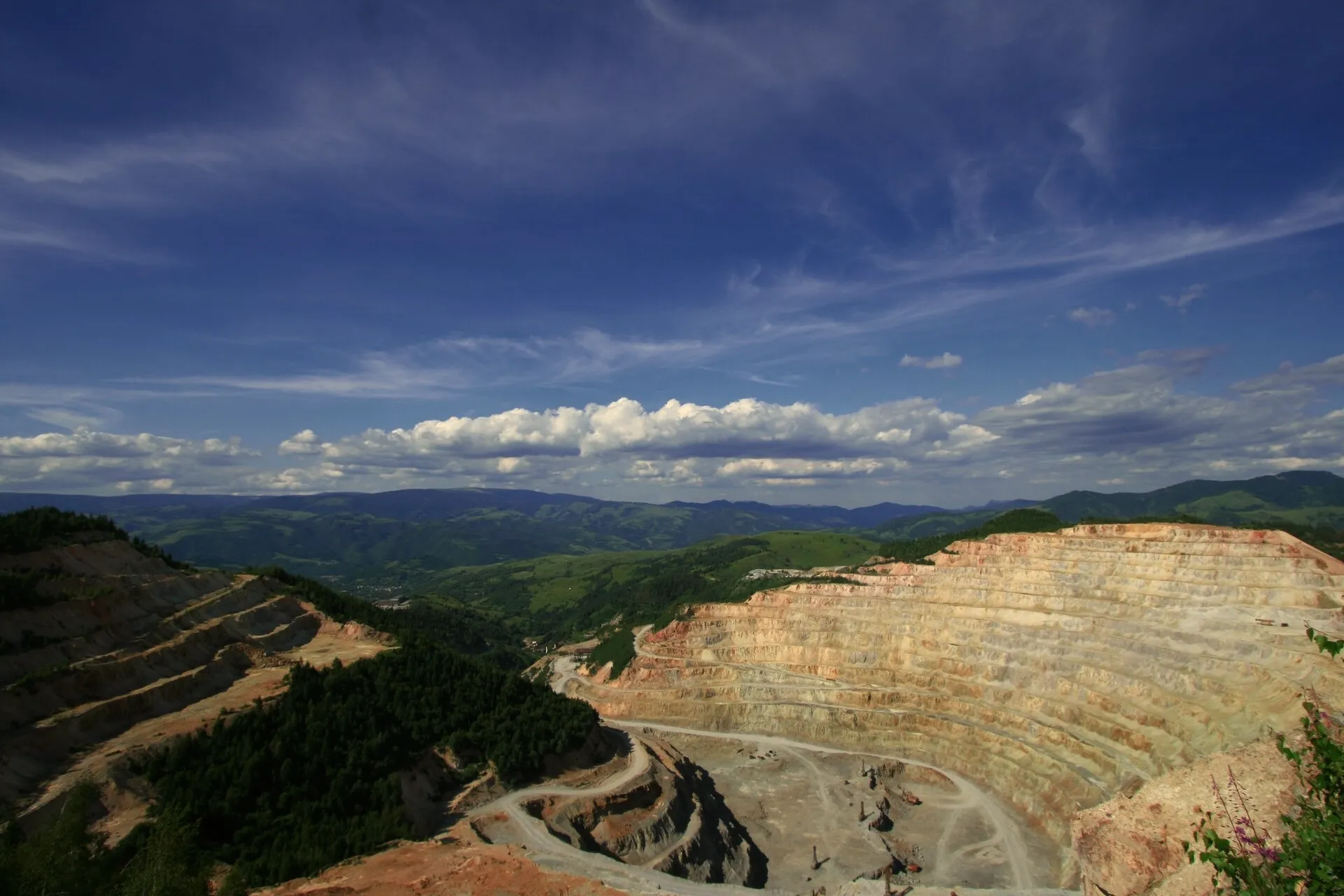 Benched hard-rock cut on a forested hillside alignment